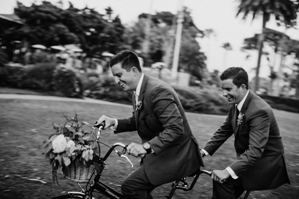 Groom and Groomsmen riding a vintage bike at his wedding at the Four Seasons in Santa Barbara by Heather Elizabeth Photography