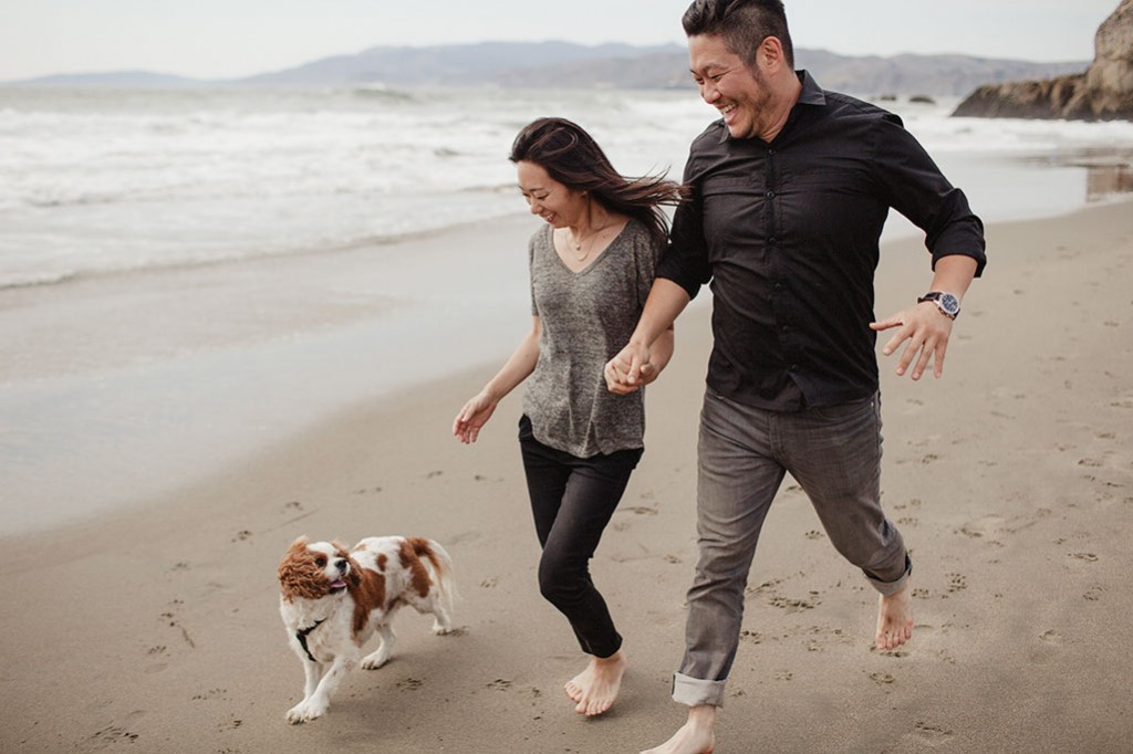 A couple during their engagement session with their dog at the Sutro Bath's by Heather Elizabeth Photography in San Francisco